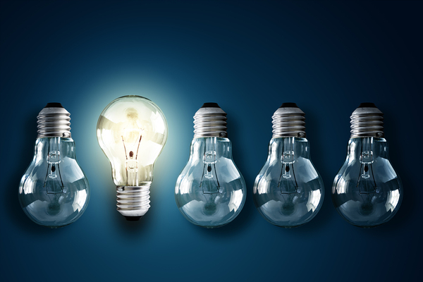 Row of lightbulbs with one lite up.