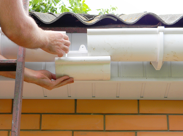 Repairing gutters on a home.