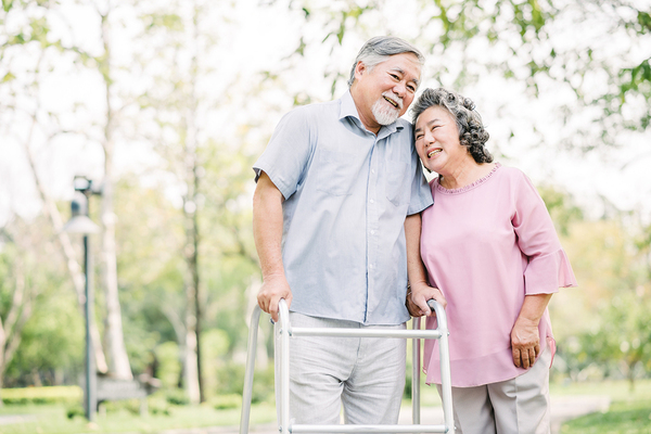 Older couple walking together using a walker.