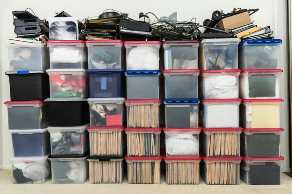 Multiple plastic storage boxes stacked with items.