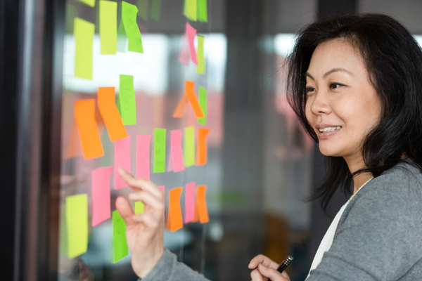 Woman placing sticky notes on a window.