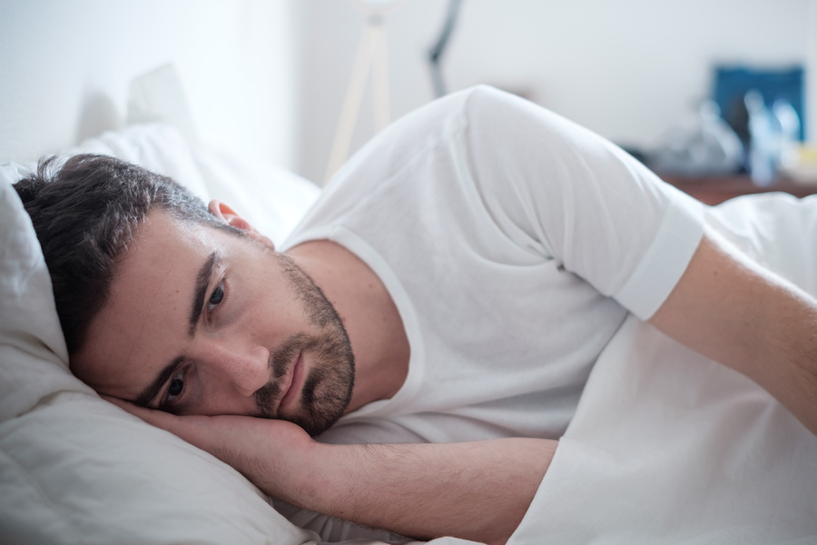 Man lying down appearing sad.