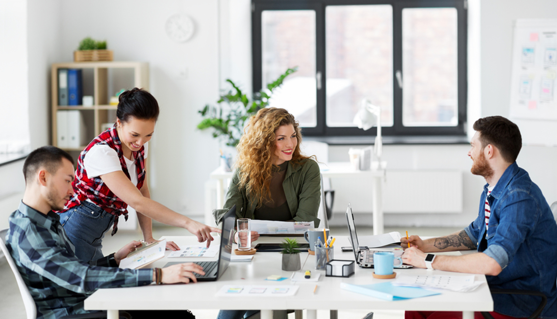 Four colleagues sitting at a conference table discussing omnichannel feedback.