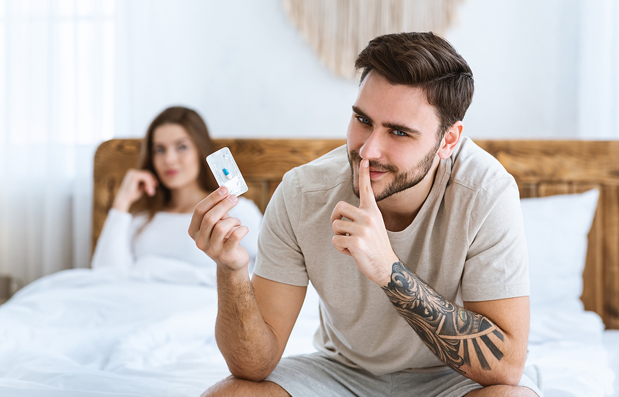 Man holding a blue pill pack.