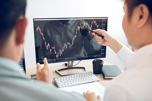 Two colleagues looking at graphical data on a screen.