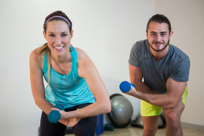 Two people working on with hand weights.