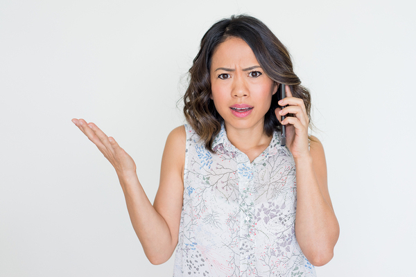 Woman on the phone appearing frustrated.