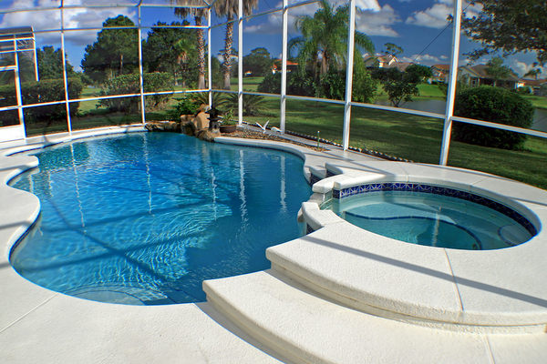 In ground pool enclosed with glass.