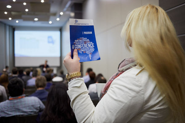 Woman at a conference holding a flyer.