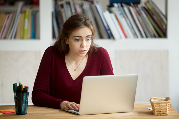 Woman sitting at her desk looking at her laptop.