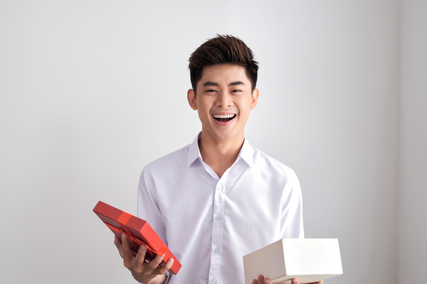 Man opening a gift box smiling.