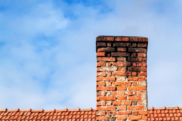 Brick chimney with black soot at the top.