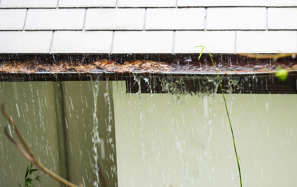 Rain falling gutters filled with debris.