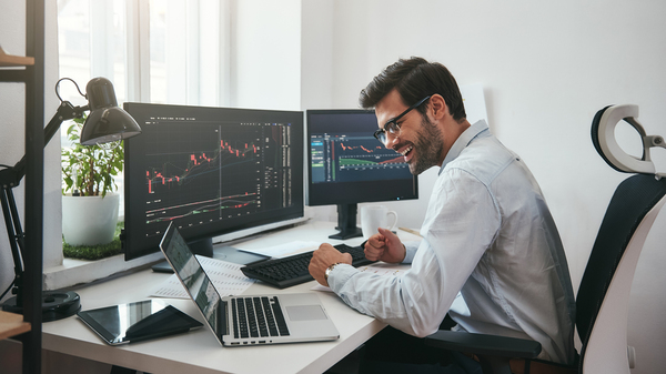 Smiling man looking at charts and graphs.