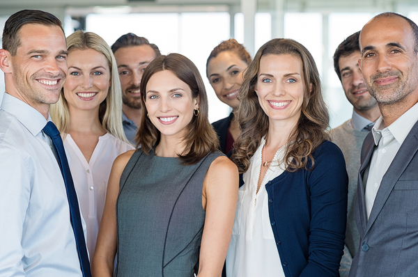 Group of people in business attire smiling.