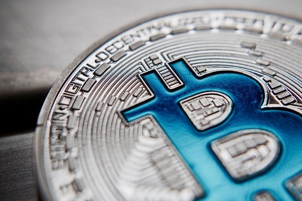 Silver Bitcoin coin with a blue B.