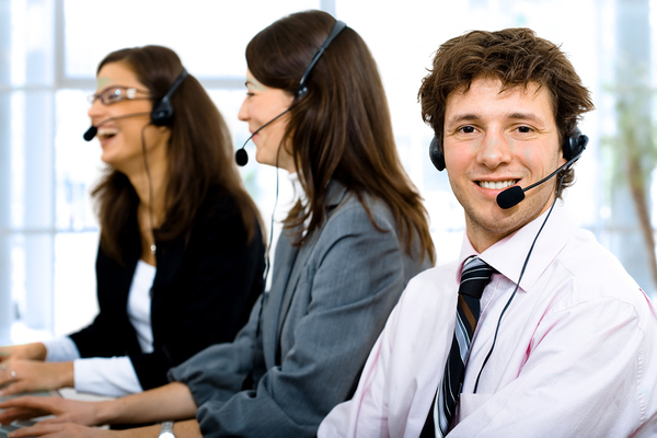 Three help desk technicians with headsets on.