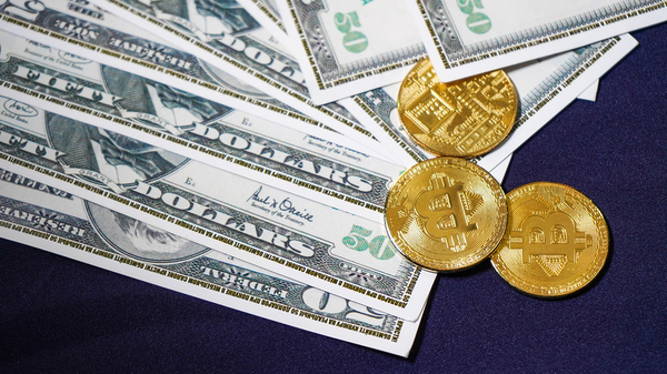 Paper money and gold coins with bitcoin symbols.