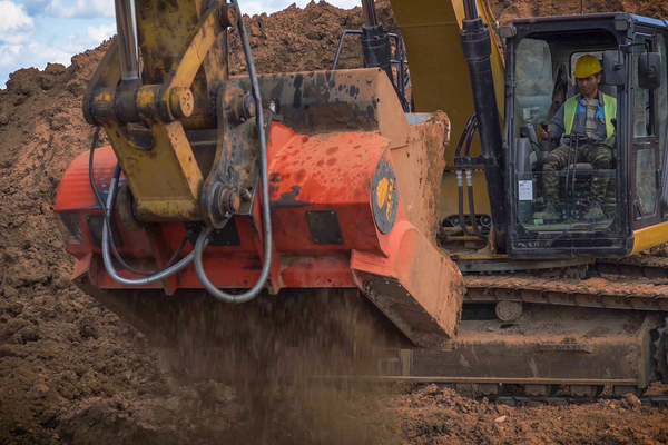 Construction working driving a backhoe.