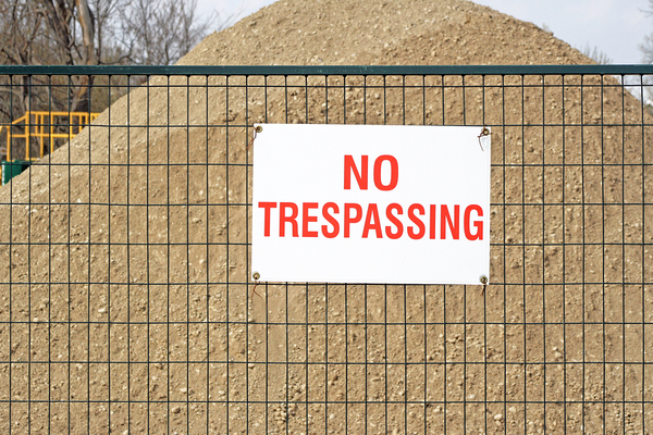 Metal fence with a sign No Trespassing.