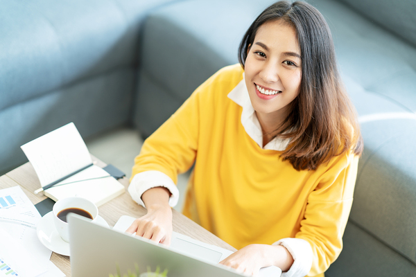 Intrapreneur smiling while working on her laptop.
