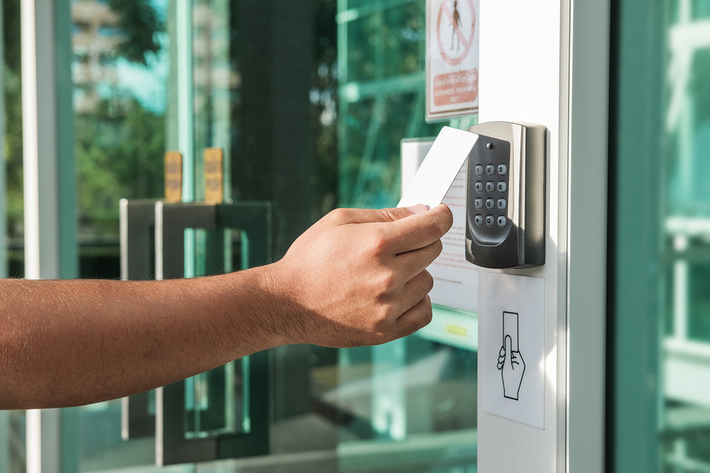 Person using their card key to open a door.