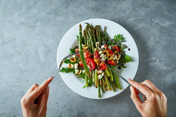 Tabletop with plate containing vegetables.