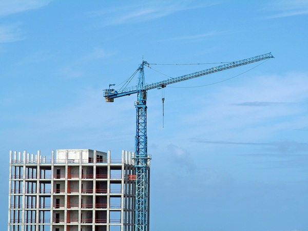 Crane on top of a tall building under construction.