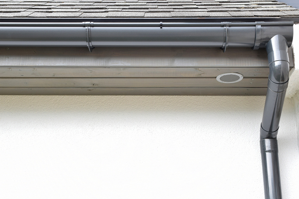 Grey gutter with downspout.