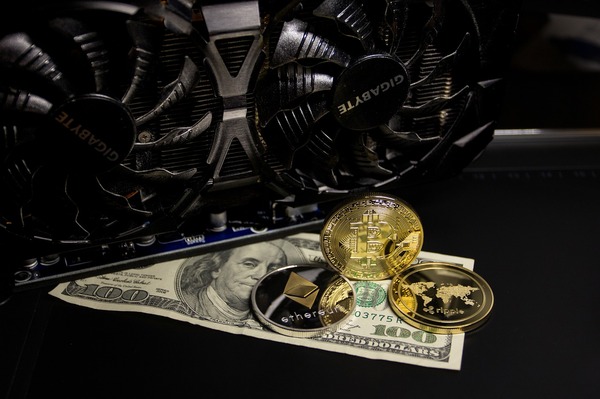 Computer fan with gold bitcoin coins and a 100 dollar bill.