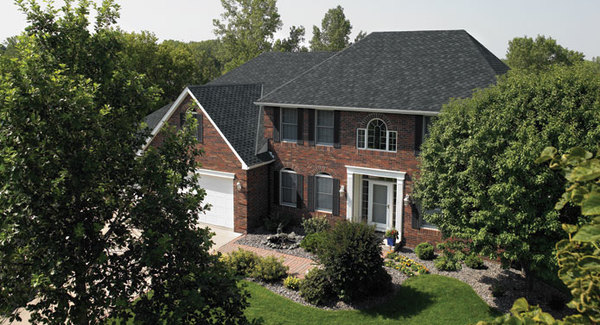 Brick front home with black shutters and white gutters.