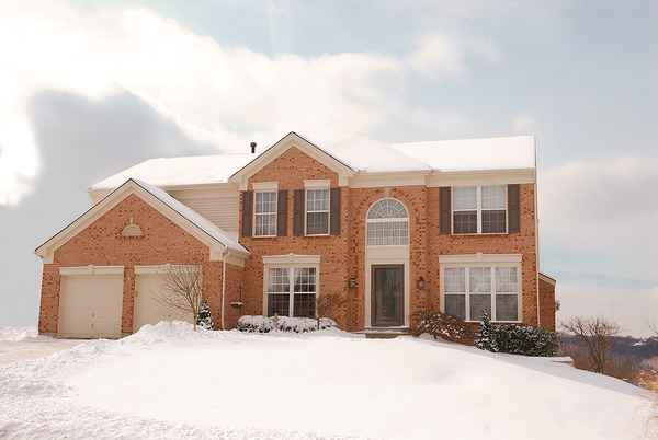 Brick front home with snow on the roof.