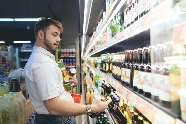 Man shopping in a grocery store buying beer.