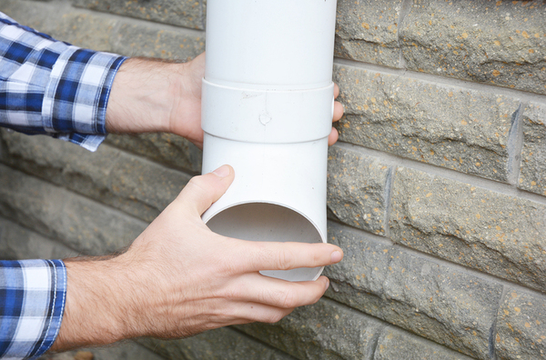 Person installing a downspout.