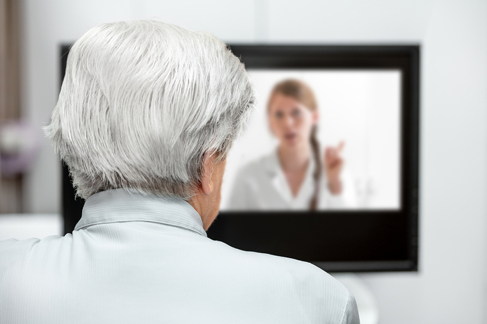 Elderly person having a video conference with a doctor.