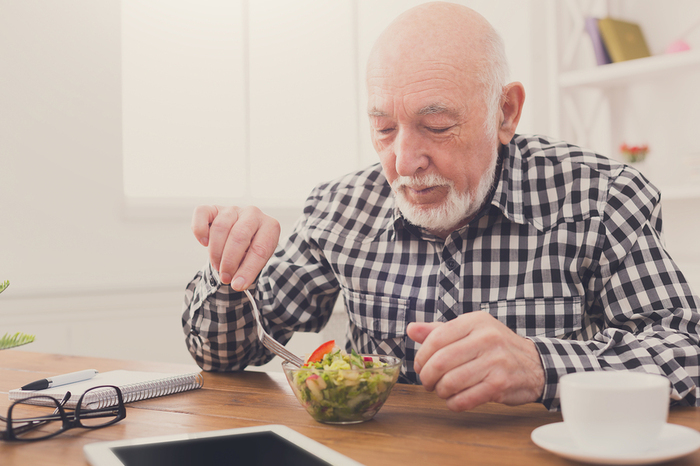 Elderly gentleman eating a healthy salad.