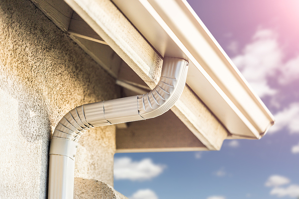 Corner of a roof with white gutters.