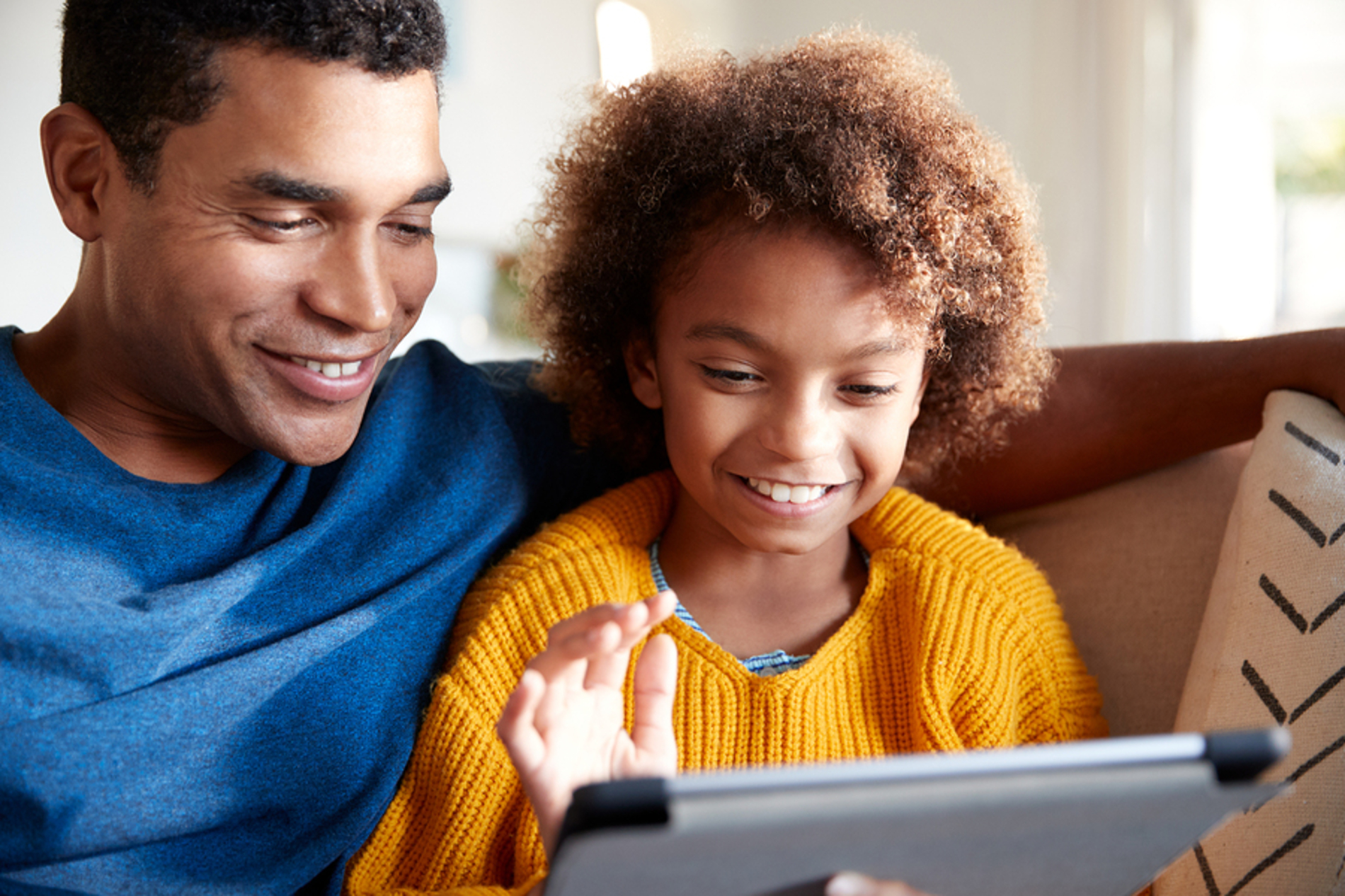 Father and child looking at a tablet together.