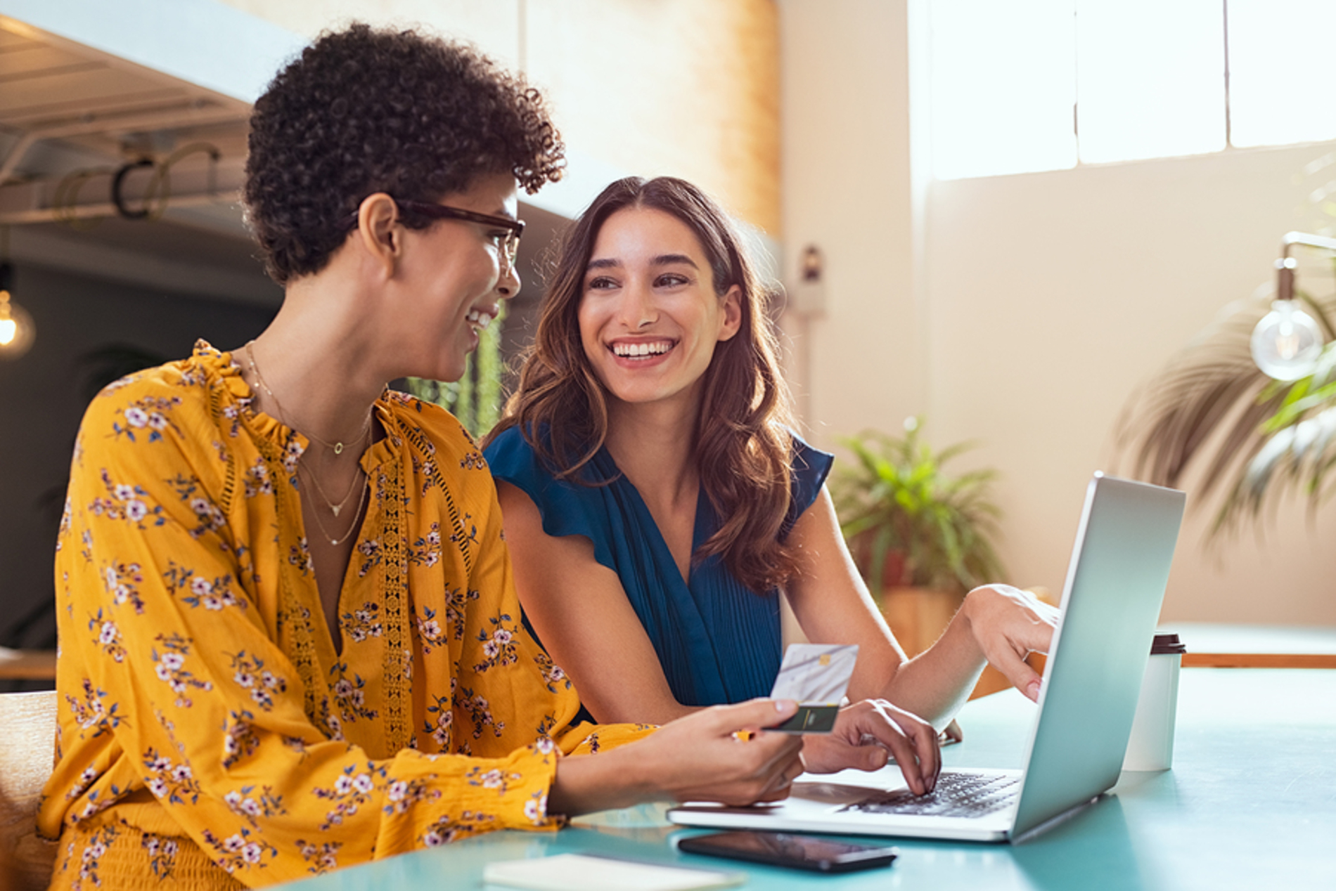 Two happy people sitting in front of a laptop smiling. Two happy people sitting in front of a laptop smiling.