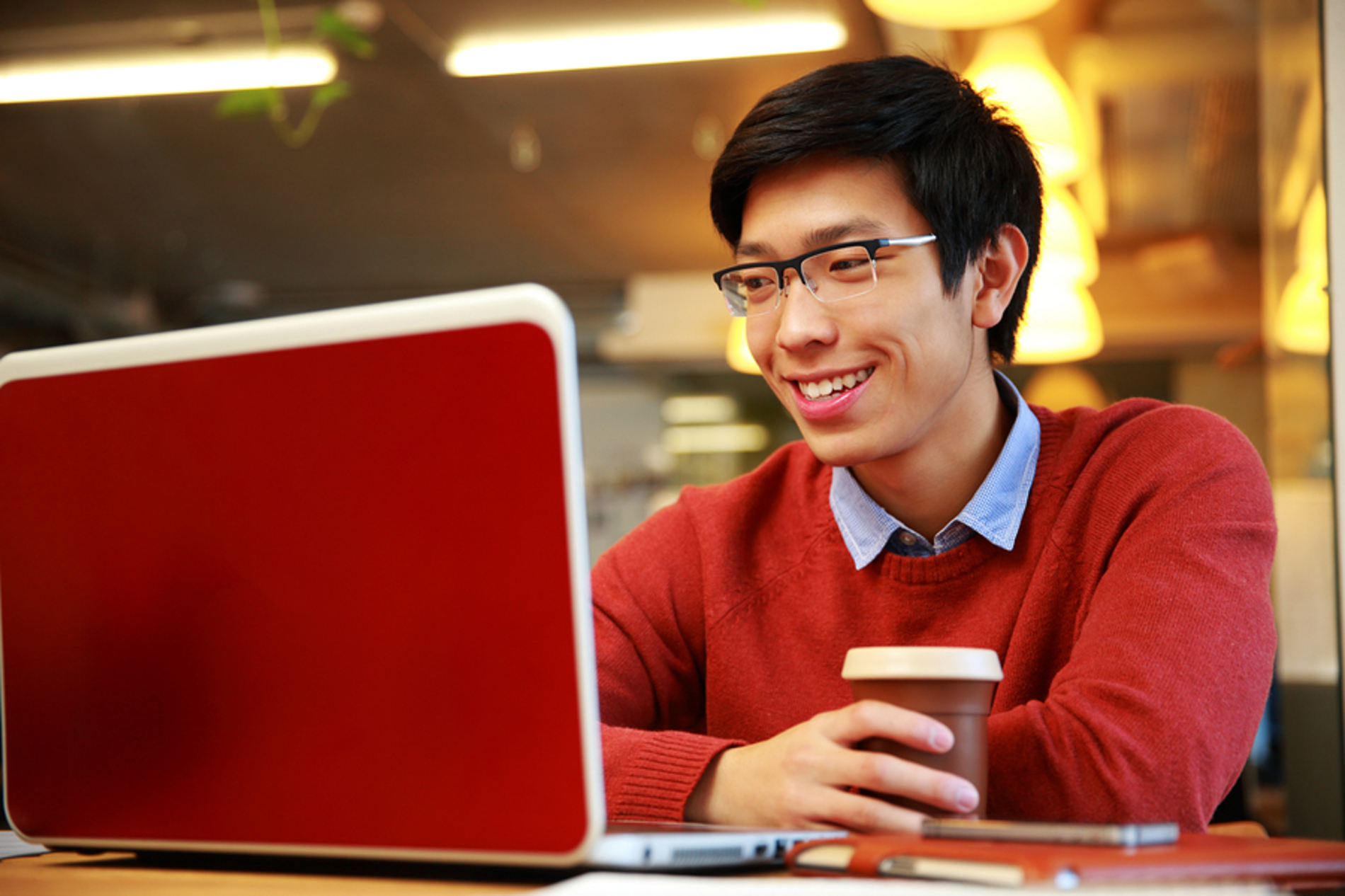 Man sitting at his desk looking at his laptop screen.