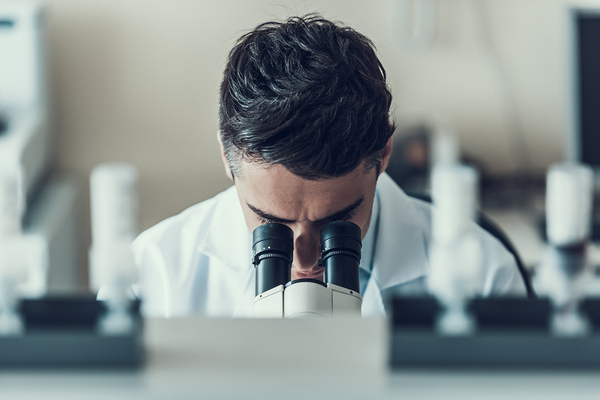 Person looking into a microscope.