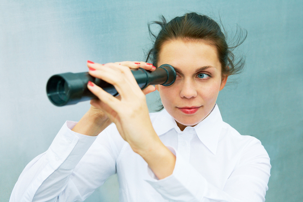 Woman looking through a telescope.