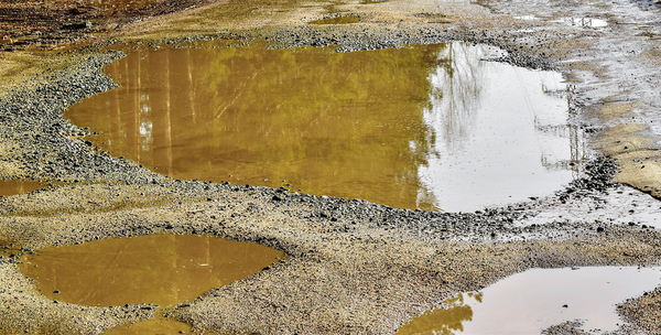 Dirt road with large puddles.
