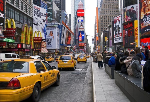 City street filled with yellow taxis and neon signs.