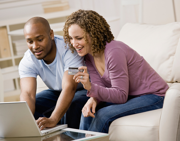 Young couple placing an order online with a laptop and credit card.