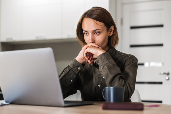 Woman looking intently at her laptop screen.