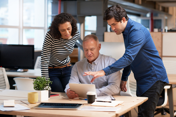 Three coworkers discussing a document.