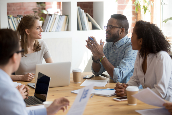 Four coworkers discussing ideas at a table.