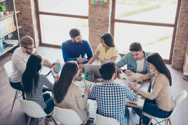 Group of people working together at a large conference table.