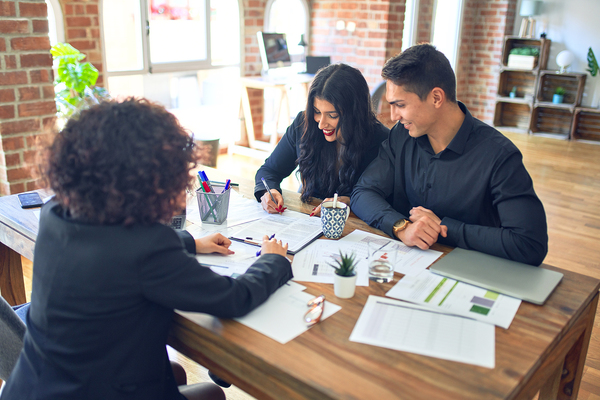 Data-driven analytics image of a smiling couple signing a document.